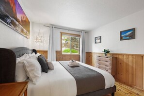 A bedroom with a bed, a dresser, a window with a view, and a painting on the wall. - Heavenly Escape | Lake Views, Pets OK | Sleeps 6 (Stateline)