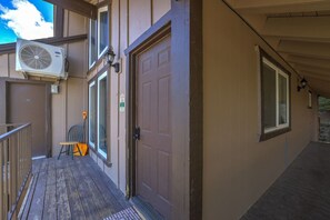 Un bâtiment doté d’un porche couvert, d’une porte et d’un appareil de climatisation.