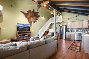 A spacious living room with a large sofa, a flat-screen TV, and a unique wall-mounted animal hide. - Ski-In Heavenly Condo | Cozy 3BR | Sleeps 8 (Stateline)