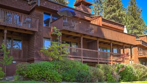 A multi-story wooden building with balconies, large windows, and a well-maintained garden. - Epic Condo | Beach Access & Meadow Views | Sleeps8 (Zephyr Cove)