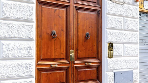 A double wooden door with brass knockers, set in a white textured wall with a number '4' above it. - Angela Luxury Home, Families Premium Apartment (Roma)