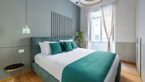 A modern bedroom with a large bed, a bedside table, a hanging light, and a view of the outside. - Angela Luxury Home, Families Premium Apartment (Roma)