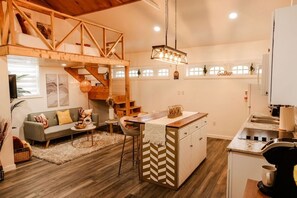A spacious loft-style apartment with a kitchen, dining area, and a loft bedroom.