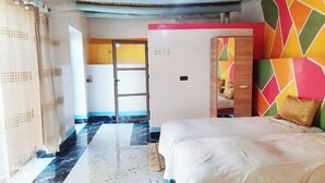 A hotel room with a bed, a wardrobe, a door, and a colorful wall. - Hotel Amodou (Tinghir)