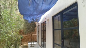 A building with large windows and a covered outdoor area. - Hotel Amodou (Tinghir)