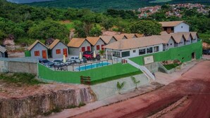 Un hôtel comprenant plusieurs bâtiments, une piscine et offrant une vue sur un paysage vallonné.