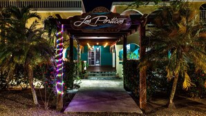 A hotel entrance with a sign reading "Los Porticos." - Luxurious 2BR Beachfront shared Pool & Modern (Placencia)