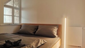 A bedroom with a bed, pillows, a blanket, a window, and a bedside lamp. - Alpenperle im Zentrum von Erfurt/nähe Domplatz (Erfurt)
