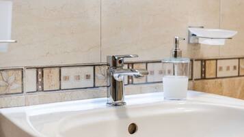 A bathroom sink with a chrome faucet and a soap dispenser.
