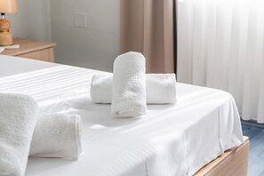 A neatly made bed with white linens and rolled towels. - The Old-Clock Apartment by PikHost (Shkodër)