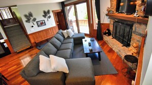 A modern living room with a sectional sofa, a fireplace, and a television.