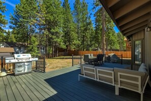 A deck with a grill, outdoor seating, and a view of a forest. - Modern 5BR Home | Chef’s Kitchen | BBQ | Sleeps 10 (Stateline)