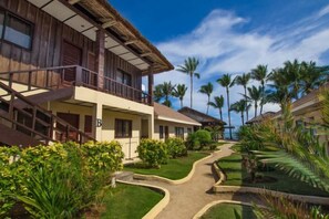Un resort con edifici a più piani, un viale centrale e palme.