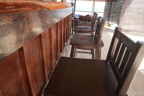 A row of wooden tables and chairs in a covered outdoor seating area. - Levantin Boracay (Boracay Island)