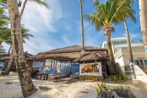 A beachside hut with a thatched roof, palm trees, and a signboard. - Levantin Boracay (Boracay Island)