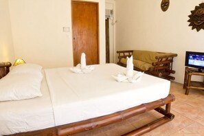 A room with a bed, a wooden bench, a television, and a door. - Levantin Boracay (Boracay Island)