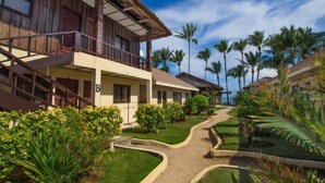 A resort with wooden buildings, a pathway, and palm trees. - Levantin Boracay (Boracay Island)