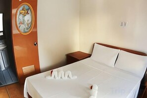 Une chambre d’hôtel avec un lit, une table de chevet et un téléviseur fixé au mur.