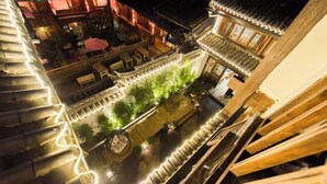 A traditional courtyard with a wooden fence, a seating area, and a small garden. - Yuetu Shishanju, Lijiang Ancient City (Lijiang)