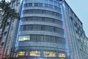 Um edifício moderno com fachada curva e vários andares.