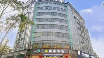 A multi-story hotel with a curved facade, large windows, and a visible restaurant at the ground level.
