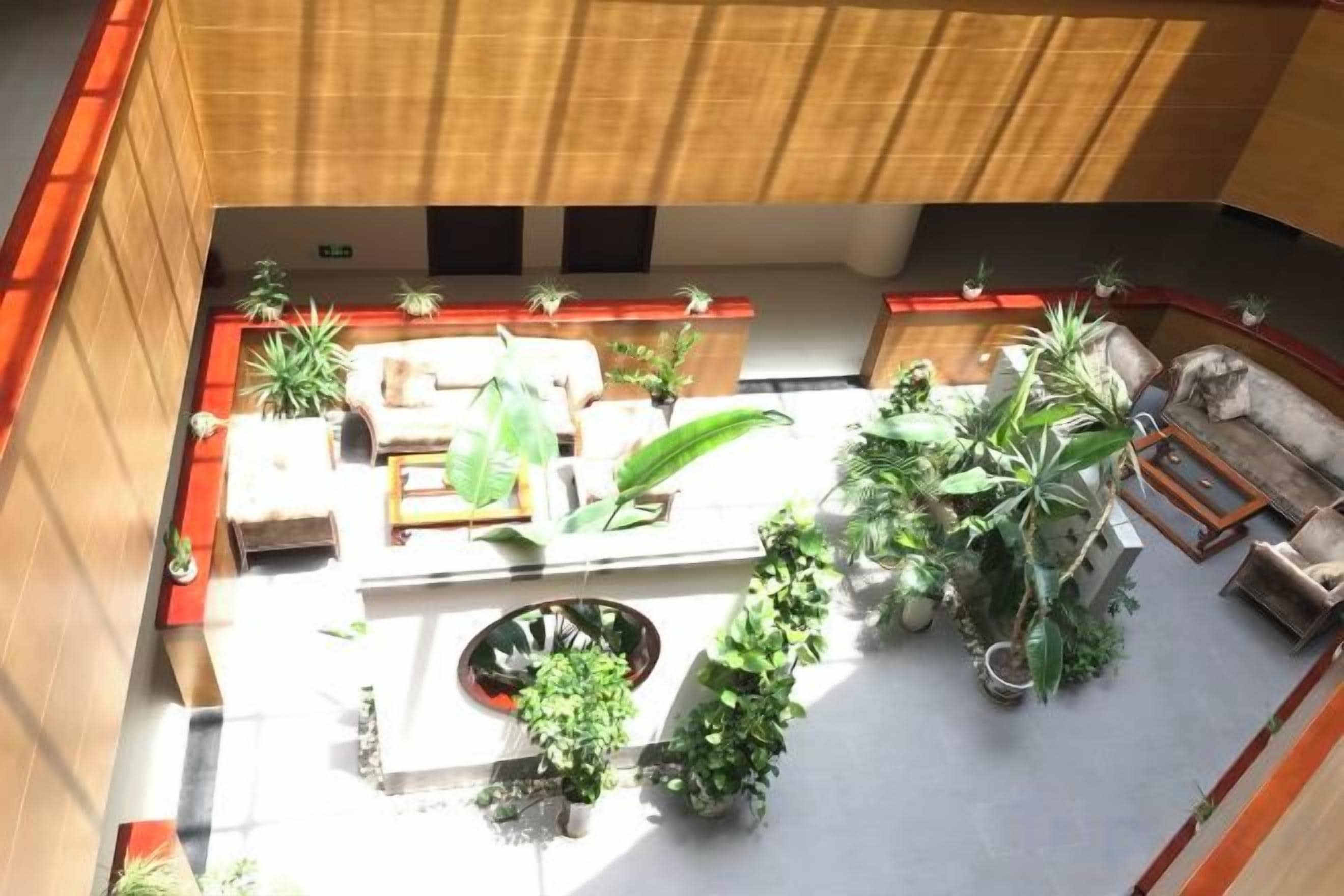 An indoor courtyard with seating areas, potted plants, and a central water feature.