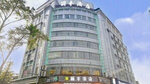 A multi-story hotel with a modern glass facade and signage for 'Li Li Feng Hotel' at the ground level. - Lifeng Hotel (Zhaoping)