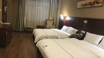 A hotel room with two beds, a chair, a desk, and a painting on the wall.