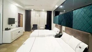 A hotel room with two beds, a TV, a desk, and a chair. - Lifeng Hotel (Zhaoping)
