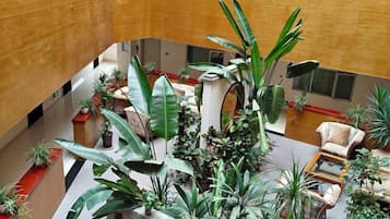 A multi-level atrium with various plants, seating areas, and a central staircase.