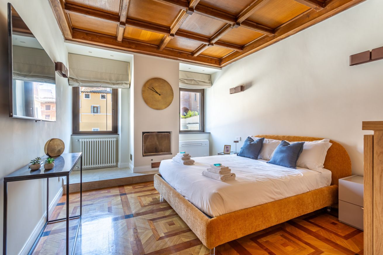 A bedroom with a bed, bedside table, and a window.