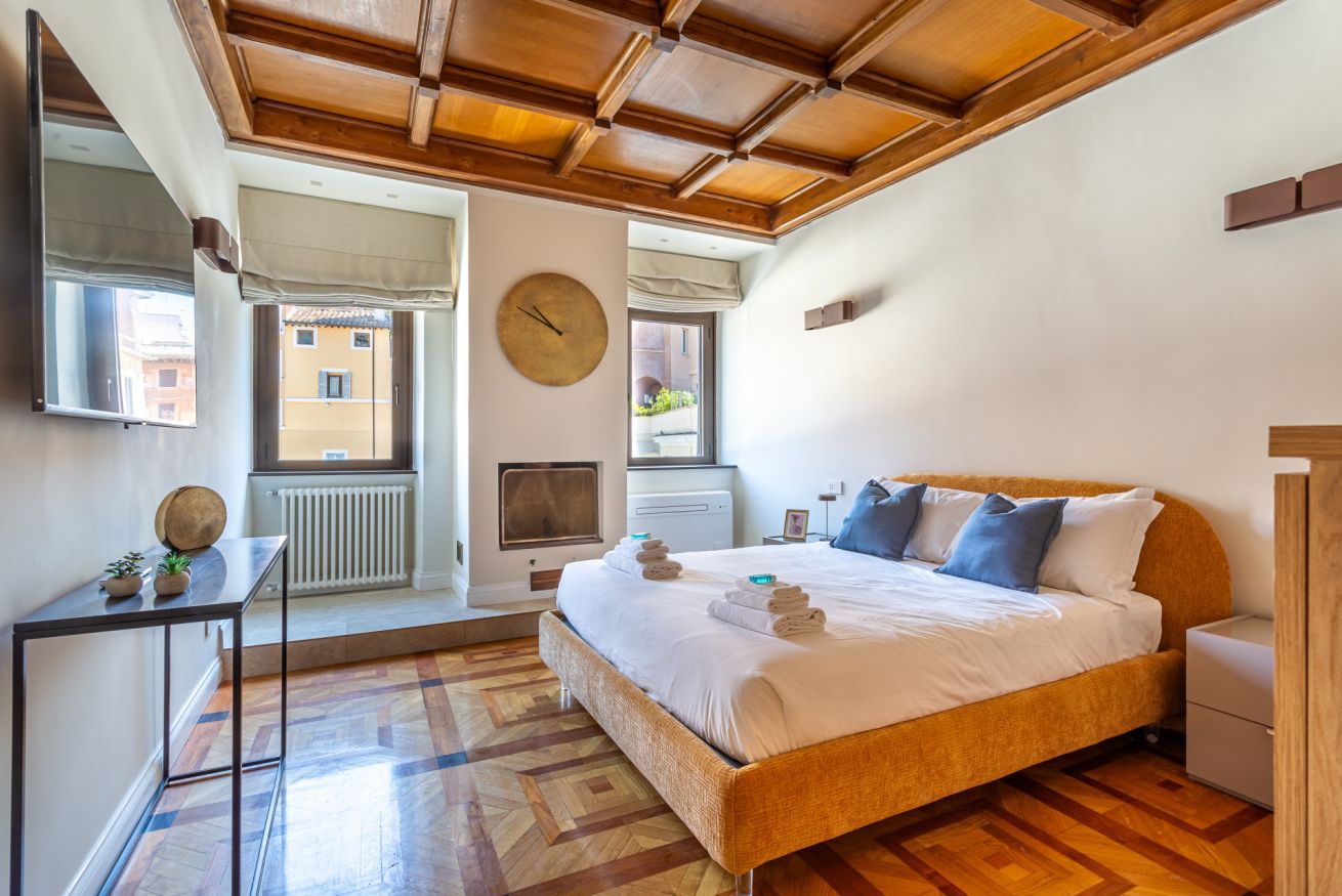 A bedroom with a bed, bedside table, and a window.