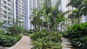 A residential building with multiple floors, surrounded by lush greenery and a paved pathway. - Southlink Lifestyle Apartment Bangsar (Kuala Lumpur)