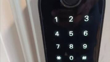 Un teclado numérico negro en una cerradura de puerta.