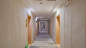 A long, narrow hotel corridor with doors on both sides, a patterned carpet, and recessed lighting on the ceiling. - Vienna Hotel (Beijing Wukesong Dacheng Road) (Beijing)