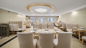 A hotel dining area with round tables, chairs, and a modern ceiling design. - Vienna Hotel (Beijing Wukesong Dacheng Road) (Beijing)