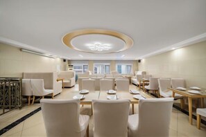 A hotel dining area with round tables, chairs, and a modern ceiling design. - Vienna Hotel (Beijing Wukesong Dacheng Road) (Beijing)
