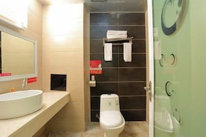 A bathroom with a sink, toilet, and a glass shower door. - Duoke Chain Hotel (Mengla)