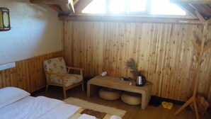 A wooden room with a bed, a chair, a small table, and a window. - Dongli Yashe Hotel (Jing County)