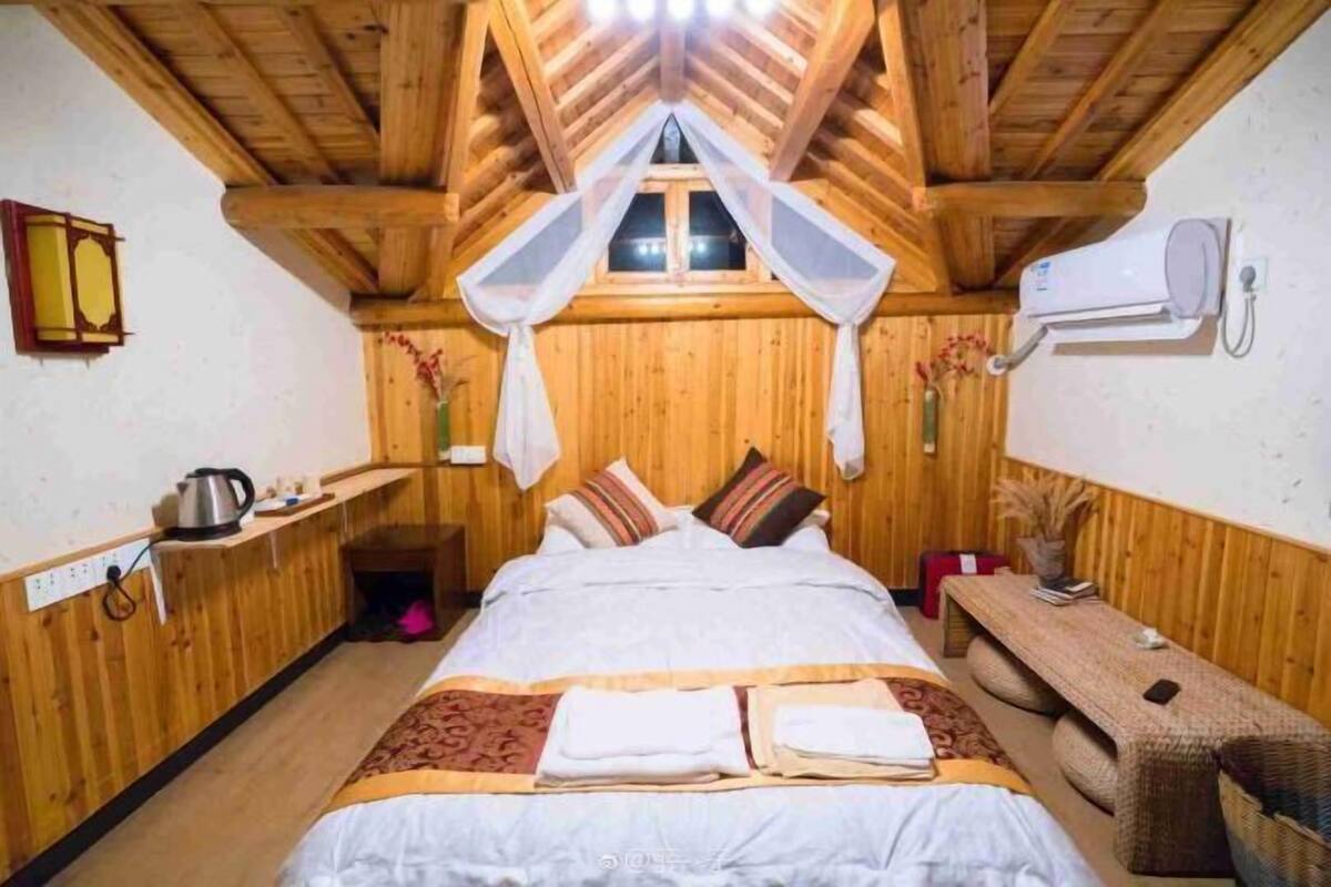 A cozy wooden room with a bed, a bench, and a small table.
