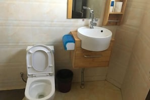 Un baño con inodoro, lavabo y espejo.