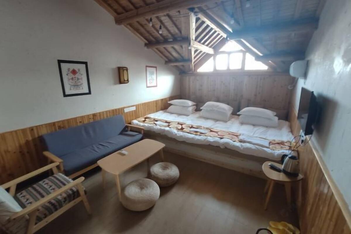 A cozy room with a bed, a sofa, a small table, and a chair.