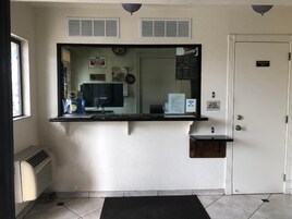 A reception area with a counter, a mirror, a door labeled "Employee Only," and a sign indicating Wi-Fi availability.