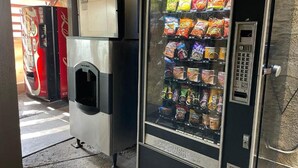 A vending machine with snacks and a soda dispenser. - Sierra Inn (South el Monte)