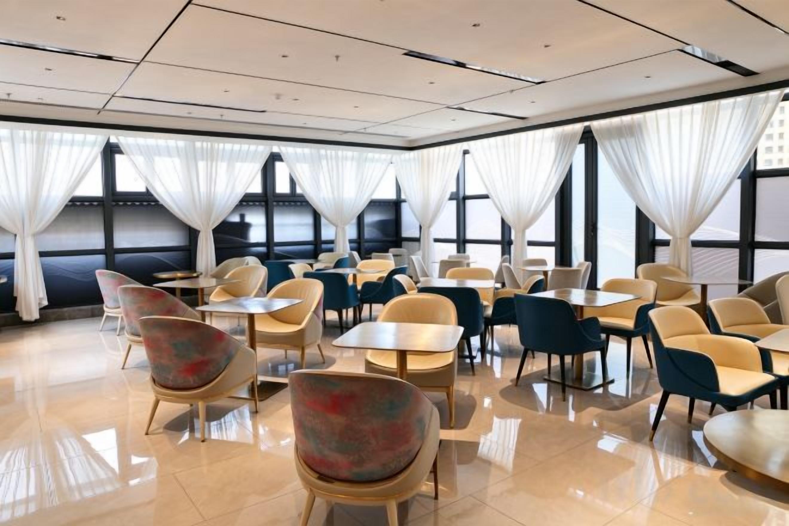 A hotel dining area with tables and chairs arranged for guests.