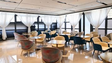 A hotel dining area with tables and chairs arranged for guests.