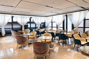 Comedor de hotel con mesas y sillas dispuestas para los huéspedes.