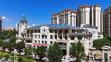 A large, historic building with a prominent dome and tower, surrounded by modern high-rise buildings.