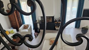 Una sala de estar con un sofá blanco, una mesa de centro y un mueble para la televisión.