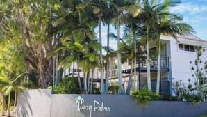 Ein Resort mit einem modernen Gebäude, Palmen und einem Schild, auf dem 'PooPals Resort' steht.